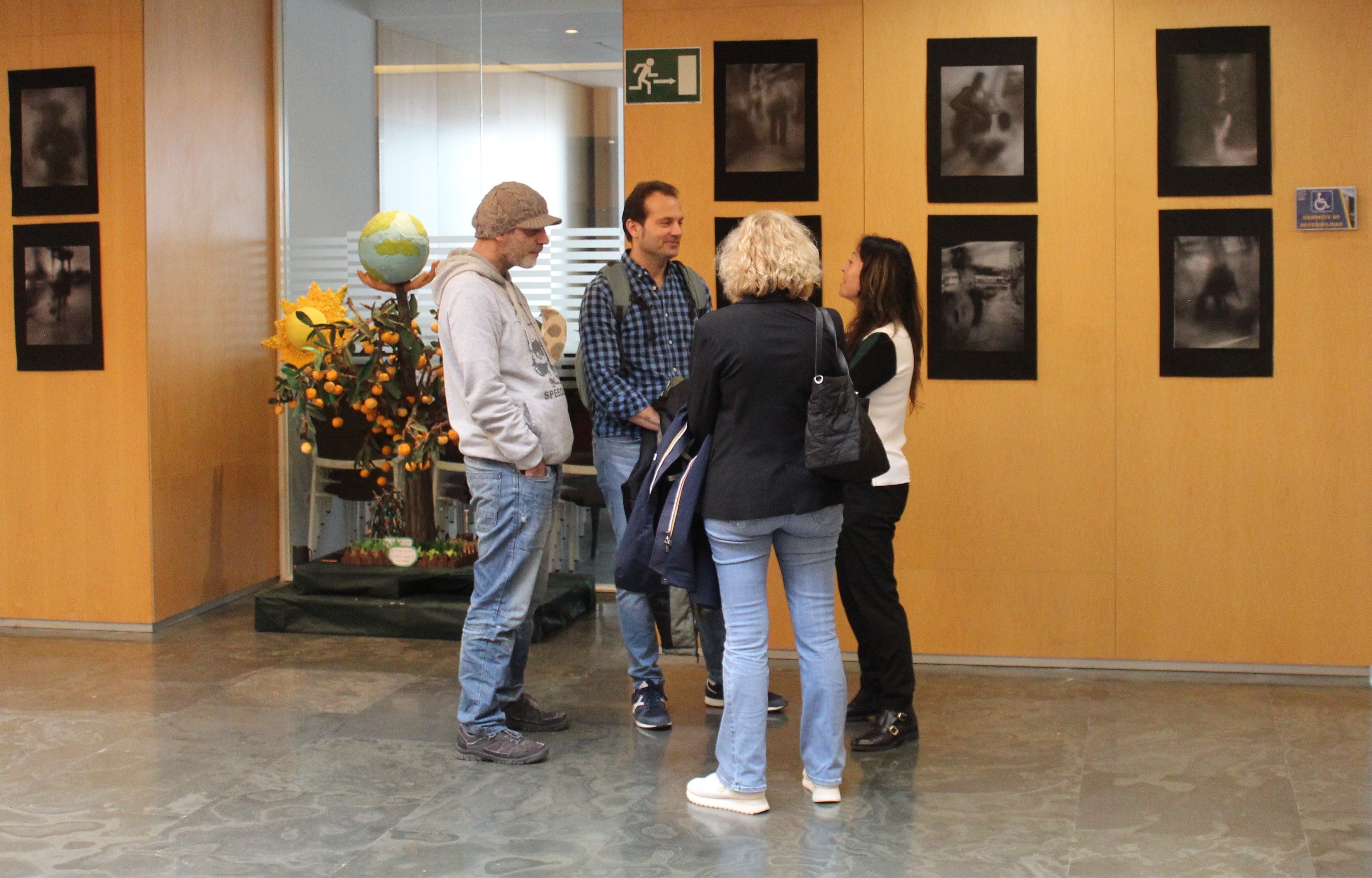 Los artistas reunidos en conversación delante de la exposición.