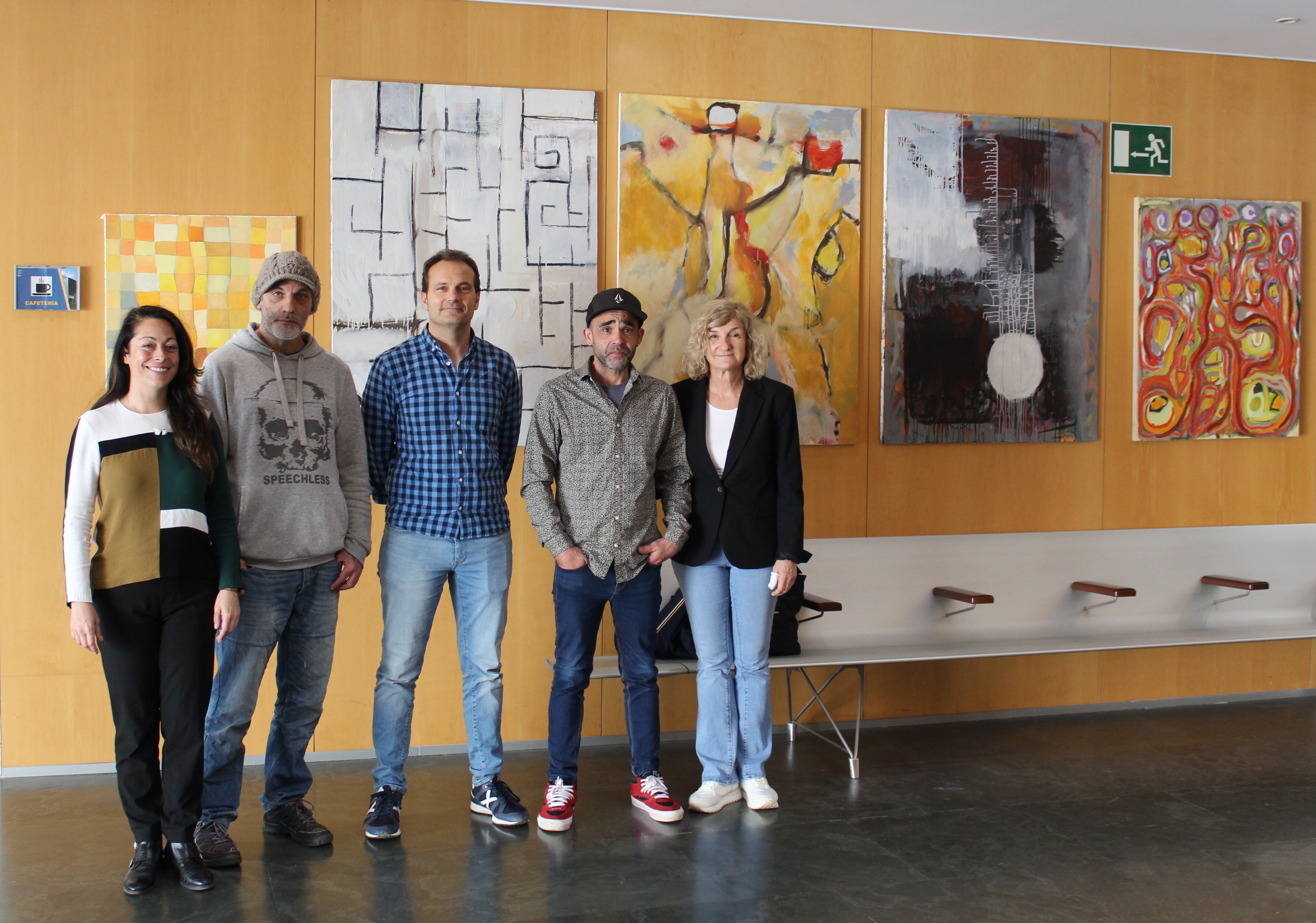 Los artistas posando junto a la exposición.