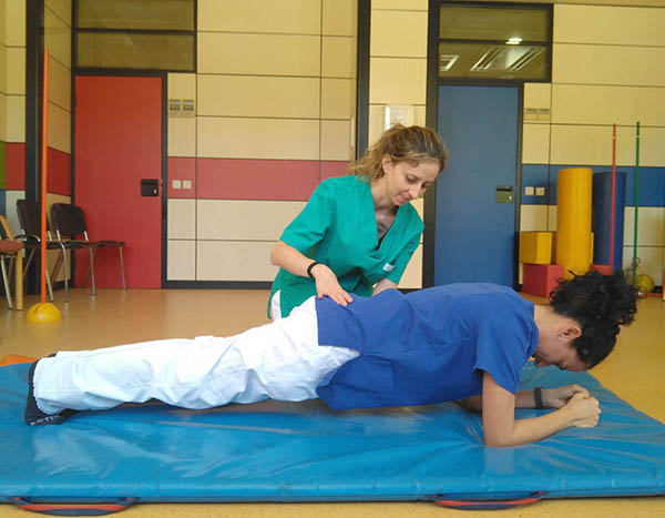 Fisioterapeutas realizando ejercicios de mejora del control postural.